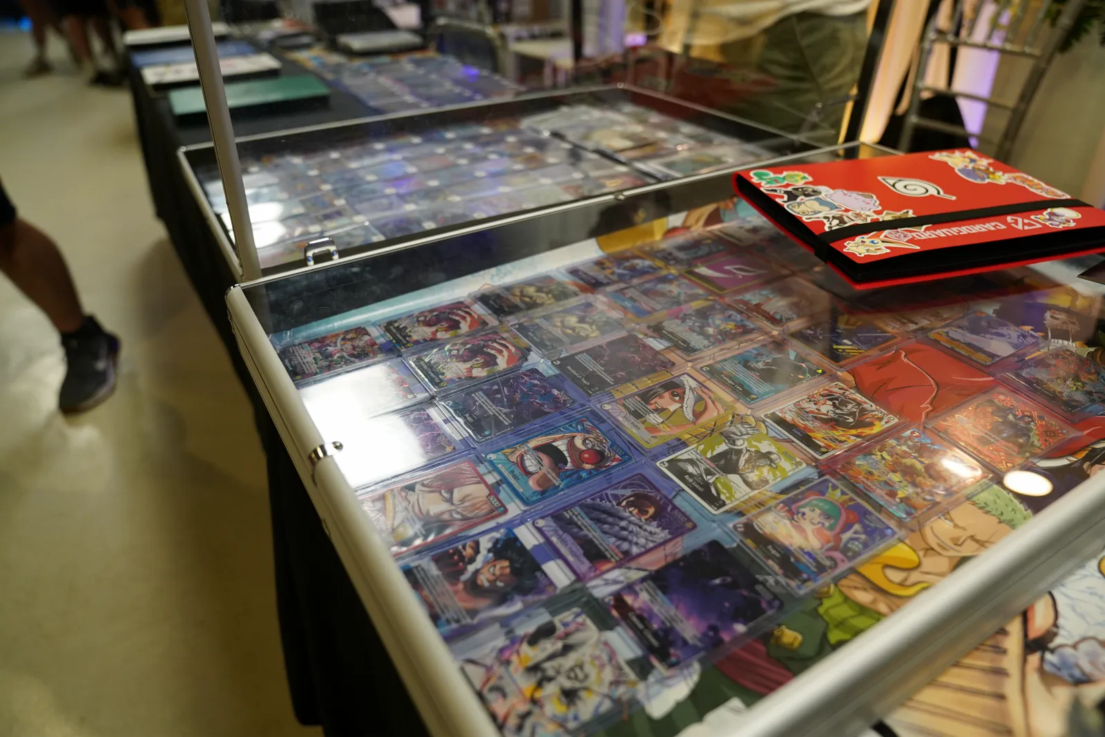 Display cases of graded trading cards and collector binders on a vendor table